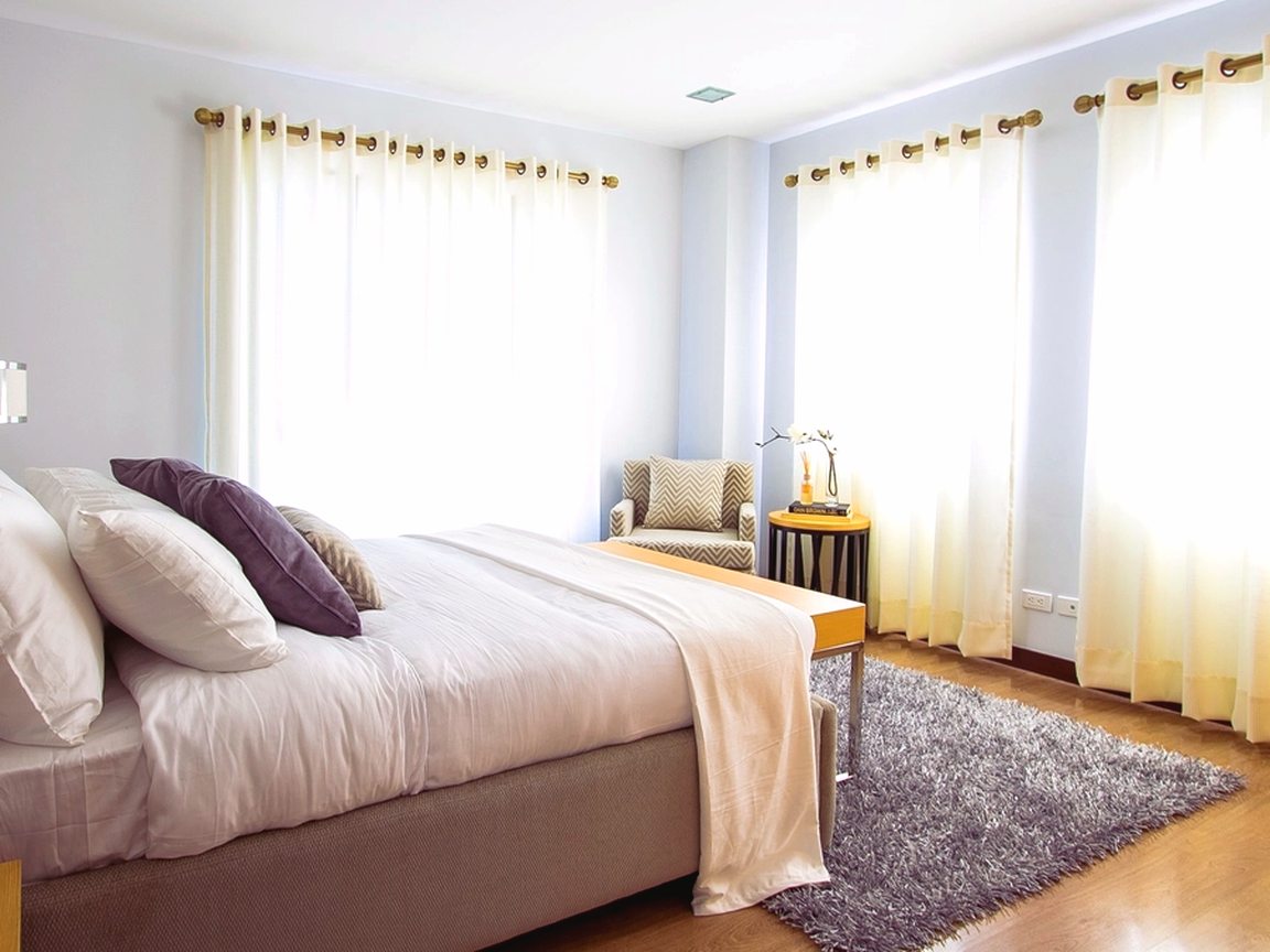 Hotel-grade bedroom with crisp white linens in natural daylight